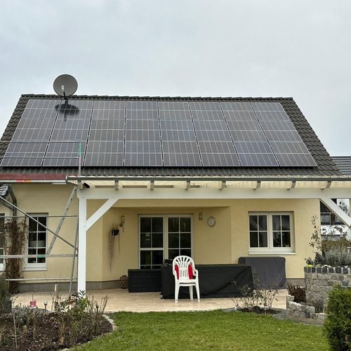 Wohnhaus mit Garten, Terrasse und Solarpanelen auf dem Dach